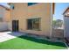 The backyard features artificial turf, a small garden, access to the home, and a secure, gated fence at 6476 Ness Gardens Ct, Las Vegas, NV 89122