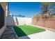 Small backyard features green artificial turf, a concrete patio, and a secure surrounding brick and wooden fence at 6476 Ness Gardens Ct, Las Vegas, NV 89122
