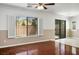 Living room featuring wood floors, a ceiling fan, shutters, and sliding glass doors at 6476 Ness Gardens Ct, Las Vegas, NV 89122