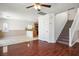 Open-concept living room featuring hardwood floors, staircase and an adjacent kitchen at 6476 Ness Gardens Ct, Las Vegas, NV 89122