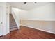 Spacious living room with wood flooring, a staircase with white railing, and neutral paint at 6476 Ness Gardens Ct, Las Vegas, NV 89122