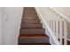 Wooden staircase with white railing and natural light from the upper level at 6476 Ness Gardens Ct, Las Vegas, NV 89122