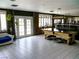 Spacious game room with tile flooring, pool table, brick accents, and access to the backyard at 6540 Tara Ave, Las Vegas, NV 89146