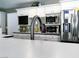 Modern kitchen features white cabinets, black countertop trim, stainless steel appliances, and a sleek faucet at 6540 Tara Ave, Las Vegas, NV 89146