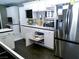 Modern kitchen features white cabinetry, a built-in TV, stainless steel appliances, and a convenient pull-out shelf at 6540 Tara Ave, Las Vegas, NV 89146