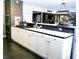 Spacious kitchen includes ample counter space, white cabinetry, stainless steel appliances, and brick accent wall at 6540 Tara Ave, Las Vegas, NV 89146