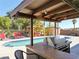 Backyard area featuring an outdoor kitchen, swimming pool, hot tub gazebo, and comfortable lounge seating for relaxing at 6540 Tara Ave, Las Vegas, NV 89146