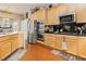 Kitchen showcasing stainless steel appliances, wooden cabinetry, and black countertops at 6617 Golden Bit Ave, Las Vegas, NV 89131