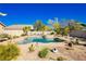 Sparkling swimming pool and spa surrounded by desert landscape and the home's exterior in the background at 6617 Golden Bit Ave, Las Vegas, NV 89131