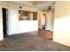 Open-concept living room featuring neutral carpet and wood flooring, leading into the kitchen and other rooms at 6955 Durango Dr # 3092, Las Vegas, NV 89149