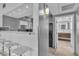 Hallway view into bathroom and kitchen features modern fixtures, stainless steel appliances and sleek white cabinetry at 6955 N Durango Dr # 1074, Las Vegas, NV 89149
