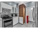 A modern kitchen view with stainless steel appliances, white cabinets and view to in-unit laundry space at 6955 N Durango Dr # 1074, Las Vegas, NV 89149