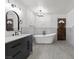 A stylish bathroom features a freestanding tub, modern fixtures, and an elegant vanity with a sleek countertop at 6995 Rogers St, Las Vegas, NV 89118