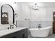 Modern bathroom features a freestanding tub, dark vanity, and stylish lighting fixture at 6995 Rogers St, Las Vegas, NV 89118