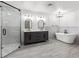 Spacious bathroom featuring double vanities, a freestanding tub, and glass-enclosed shower at 6995 Rogers St, Las Vegas, NV 89118