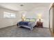 Simple and spacious bedroom with carpet, two lamps on nightstands, and natural light from the window at 6995 Rogers St, Las Vegas, NV 89118