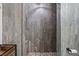 Close up of a stone tiled walk-in shower featuring rustic wood style tiles at 6995 Rogers St, Las Vegas, NV 89118