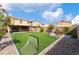 Landscaped backyard featuring turf, trees, lounge furniture, and a full playground set at 7322 Dazzle Point St, North Las Vegas, NV 89084