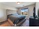 Bedroom featuring a tufted headboard, neutral color scheme and view to the exterior at 7322 Dazzle Point St, North Las Vegas, NV 89084