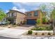 A two-story home featuring desert landscaping and a brick-paved driveway, with a dark-colored garage door at 7322 Dazzle Point St, North Las Vegas, NV 89084