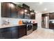 Well-lit kitchen with dark cabinetry, stainless steel appliances, and light granite countertops at 7322 Dazzle Point St, North Las Vegas, NV 89084