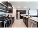 Contemporary kitchen with stainless steel appliances, dark cabinets, and a granite-topped island at 7322 Dazzle Point St, North Las Vegas, NV 89084