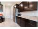 Well-lit kitchen with stainless steel refrigerator and dark cabinets with granite countertops at 7322 Dazzle Point St, North Las Vegas, NV 89084