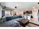 Open concept living room featuring a comfortable gray sectional sofa, leading to the kitchen and dining area at 7322 Dazzle Point St, North Las Vegas, NV 89084