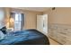 Comfortable bedroom featuring a dresser, bedside table, and window with natural light at 8000 Badura Ave # 2063, Las Vegas, NV 89113