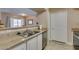 Open kitchen layout with stainless steel sink and view to living area at 8000 Badura Ave # 2063, Las Vegas, NV 89113