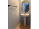 Powder room with a pedestal sink, a round mirror, and tile flooring at 8089 Windmill Villa St, Las Vegas, NV 89139