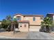 Two story home with a two car garage, desert landscaping, and a red tile roof on a clear day at 8089 Windmill Villa St, Las Vegas, NV 89139