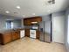 Cozy kitchen featuring stainless steel refrigerator, tile flooring, and light wood cabinets at 8089 Windmill Villa St, Las Vegas, NV 89139