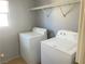 An interior laundry room featuring a full-sized washer and dryer with natural light coming in from a window at 8089 Windmill Villa St, Las Vegas, NV 89139