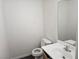 Small bathroom with a toilet, sink with mirror, and dark grey flooring at 8226 Royal Lilly Ct, Las Vegas, NV 89139