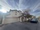 Two-story stucco home with a tile roof, arched entry, desert landscaping, two-car garage, and Cybertruck at 8226 Royal Lilly Ct, Las Vegas, NV 89139