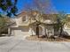 Two-story stucco home with a tile roof, arched entry, desert landscaping, and two-car garage at 8226 Royal Lilly Ct, Las Vegas, NV 89139
