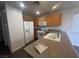 The view of a kitchen with wooden cabinetry, white appliances, and grey counter tops and flooring at 8226 Royal Lilly Ct, Las Vegas, NV 89139
