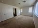 A spacious primary bedroom with carpet, two windows, and a door to the en-suite bathroom at 8226 Royal Lilly Ct, Las Vegas, NV 89139