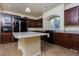 Spacious kitchen features dark cabinetry, granite countertops, stainless steel appliances, and a large island at 8467 Bismark Sapphire St, Las Vegas, NV 89139