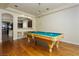 Recreation room with pool table, wood floors, and access to an adjacent kitchen and eating space at 8467 Bismark Sapphire St, Las Vegas, NV 89139