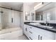 Renovated bathroom featuring double sinks, granite countertops, and a glass enclosed shower at 9005 Feather River Ct, Las Vegas, NV 89117