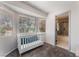 Bright Bedroom featuring a white crib, three windows, and an attached bathroom at 9005 Feather River Ct, Las Vegas, NV 89117