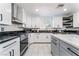 Modern kitchen featuring white cabinets, black countertops, stainless steel appliances, and a central island at 9005 Feather River Ct, Las Vegas, NV 89117