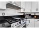 Stainless steel stovetop with white cabinets and black countertops at 9005 Feather River Ct, Las Vegas, NV 89117
