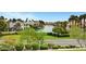 Beautiful waterfront property with lush green lawns, mature trees, and luxury homes in the background at 9005 Feather River Ct, Las Vegas, NV 89117