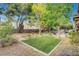 Private backyard with a covered patio, green lawn, and mature trees, offering a tranquil outdoor retreat at 950 Eagle Mountain Dr, Las Vegas, NV 89123