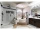 Modern bathroom with dual shower heads, tub, and a vanity with cabinetry at 9843 Frosty Canyon Ct, Las Vegas, NV 89183