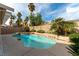 Inviting kidney-shaped pool surrounded by tropical landscaping and clear blue sky at 9843 Frosty Canyon Ct, Las Vegas, NV 89183