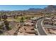 Community aerial view with desert landscaping, golf course, mountains, and homes with tile roofs at 10537 Shoalhaven Dr, Las Vegas, NV 89134